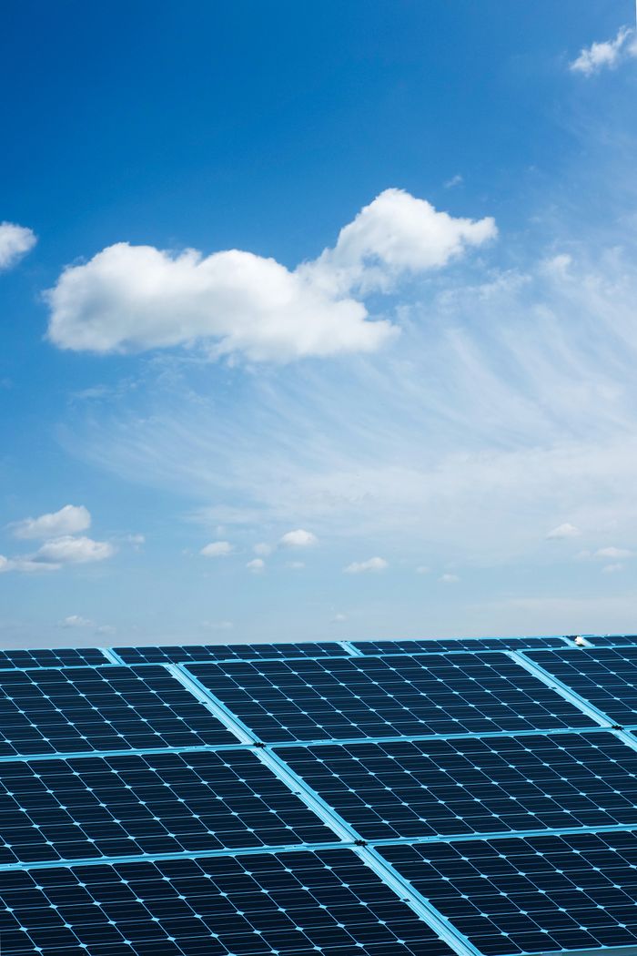 services-03 Solar panels under a clear blue sky, symbolizing renewable energy and sustainability.